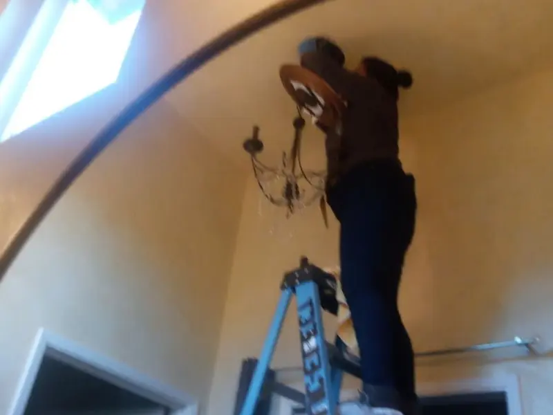 Electrician installing a chandelier in a Ocean City residence
